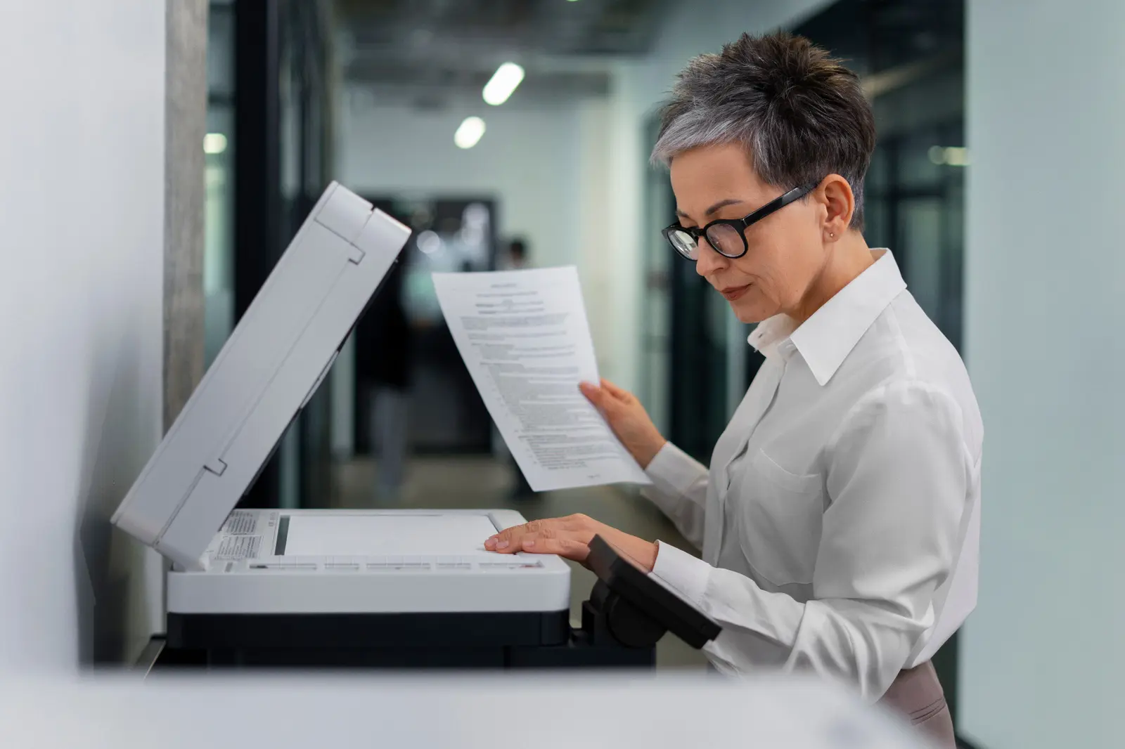 Customer reviewing printed documents while comparing printer workflow needs