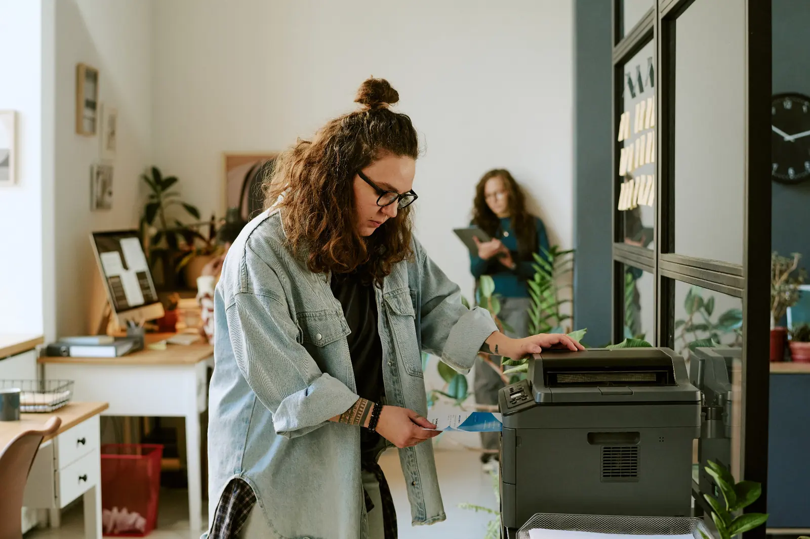 Professional using a multifunction printer in a modern office